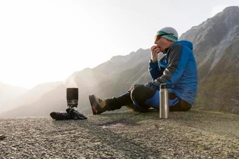 Hiker eats an apple during a break and prepares a hot tea Stock Photos