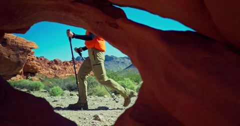 Hiker Explores Desert Landscape Through Rock Archway Stock Footage 323797041