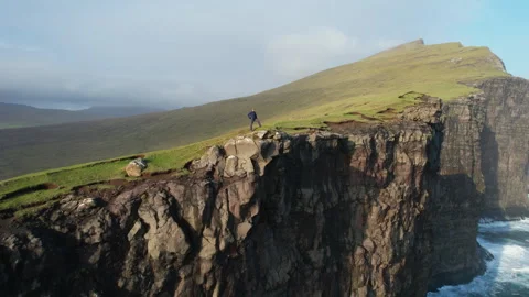 Hiker explores the dramatic cliffs of the faroe islands, showcasing the Stock Footage 308529292