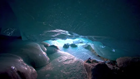 Hiker exploring a blue glacial ice cave with natural light Stock Footage 341329605
