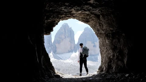 A hiker is exploring a breathtaking mountain landscape through an adventurous Stock Footage 316248328