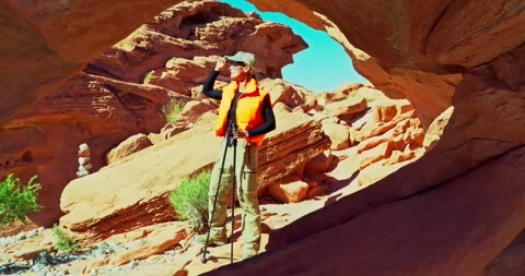 Hiker Exploring Desert Arch in Vibrant Daylight Stock Footage 323795588