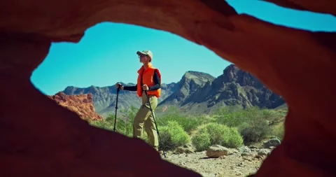 Hiker Exploring Desert Landscape Through Natural Archway 스톡 동영상 325217097
