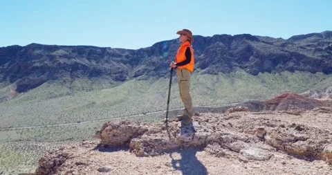 Hiker Exploring Desert Landscape with Walking Stick Vídeo Stock 325448342