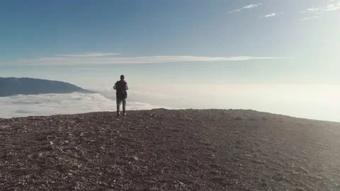 Hiker exploring high mountain above clouds Stock Footage 170586909