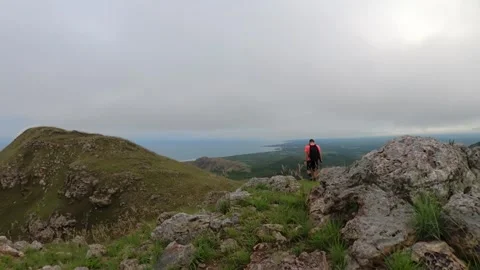 Hiker exploring scenic mountain trails overlooking the ocean Stock Footage 345100498