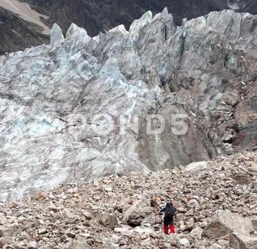 Hiker on glacier moraine Stock Photos