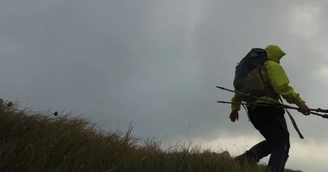 Hiker going down the mountain with trekking poles. Stock Footage 82466199
