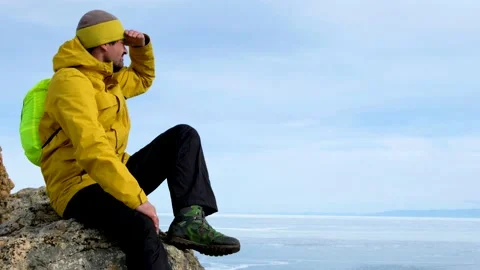 Hiker going to top and looking at ice of Baikal. Frozen lake Stock Footage 146501973