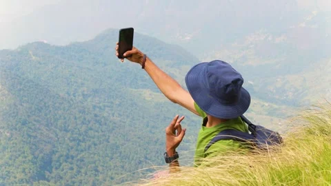 Hiker in hat taking selfie overlooking mountains near Rudranath Temple Stock Footage 345653455
