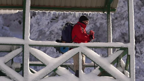 Hiker Looking Down from Snow Covered Wooden Watchtower 動画素材 315902340