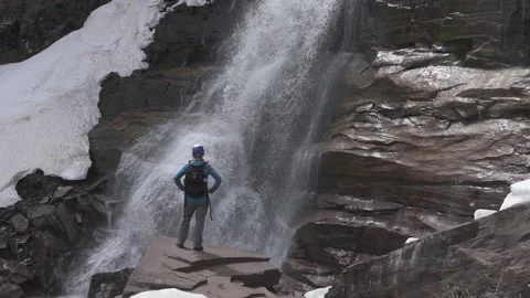 A hiker looking at a waterfall Stock Footage 144786565