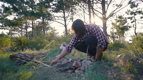 Hiker male making the campfire in forest during sunset Stock Footage 84420059