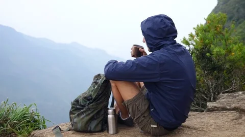 Hiker Man With Backpack Drinking Tea From Thermos On Mountain Peak Stock Footage 84987778