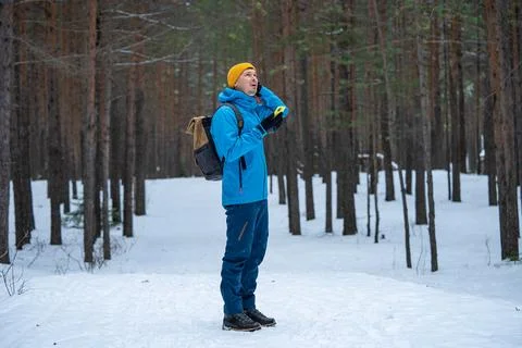 Hiker man experiencing difficulties navigating in winter forest, lost and Stock Photos