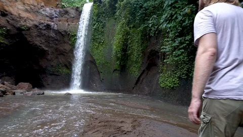 Hiker man exploring waterfall in forest. Stock Footage 89526586