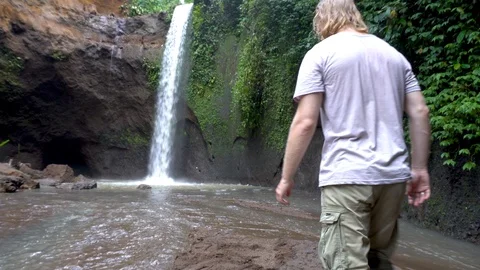 Hiker man looking at waterfall in forest. Male trekking in Bali Stock Footage 89526153