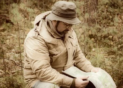 Hiker with map in forest Stock Photos