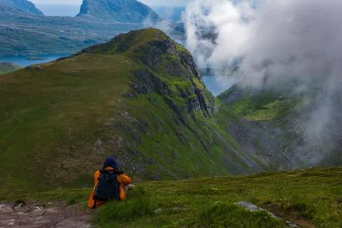 Hiker with Orange Backpack Exploring Lofoten Mountains Norway Фото