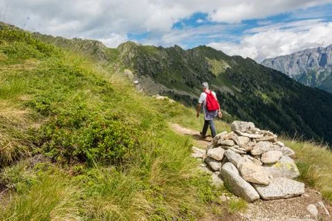 Hiker passing a stone pyramide. Stock Photos