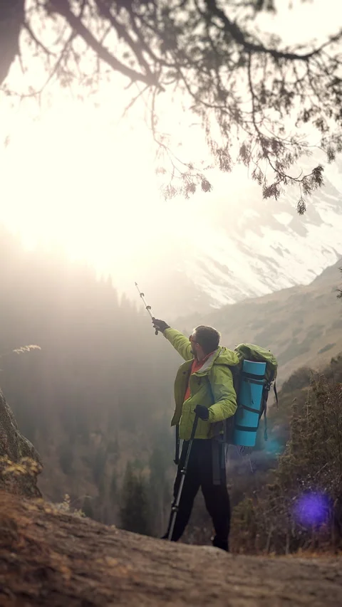 Hiker Pointing Forward Toward Mountain Sunlight Vertical Adventure Travel. Stock Footage 321576938