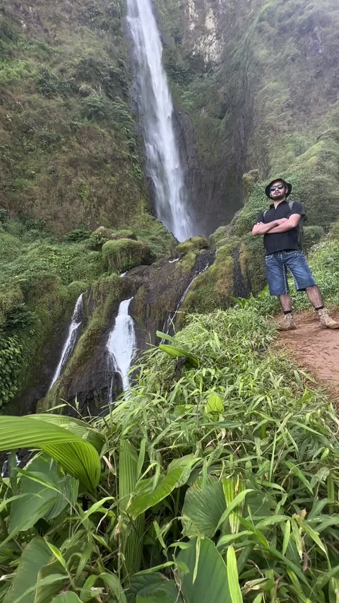 Hiker Posing at Large Waterfall in Tropical Rainforest Stock Footage 323908509
