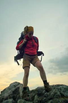 Hiker putting on a backpack Stock Photos