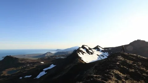 Hiker reaching the snowy mountain summit in the Snaefellsnes peninsula Stock Footage 344058765