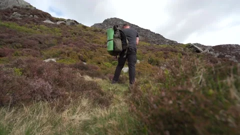 A hiker removing his backpack and running up a mountain 動画素材 200829911