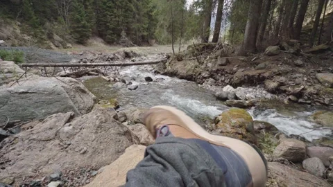 Hiker resting by mountain river contemplating nature 스톡 동영상 309849917