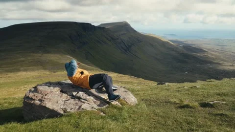 Hiker Resting on a Rock With Skye Mountains Behind Stock-Footage 338321869