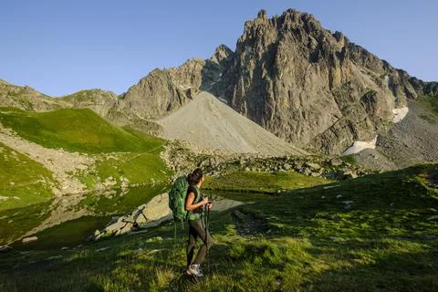 Hiker on the road, Midi d'Ossau peak, 2884 meters, and Pombie lake, Pyrenees  Stock Photos