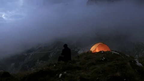 Hiker Sets Camp on a Mountain Top in the Evening Stock Footage