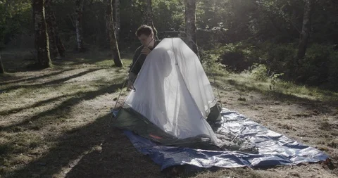 Hiker setting up a tent in the forest Stock Footage 145280582