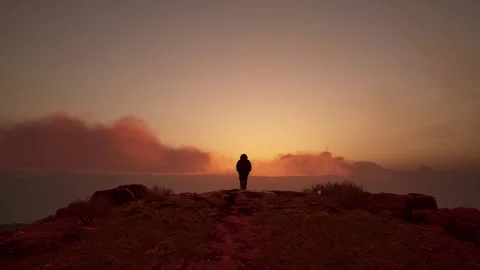 Hiker Silhouette Standing on Cliff at Dramatic Sunset Stock Footage 337813240
