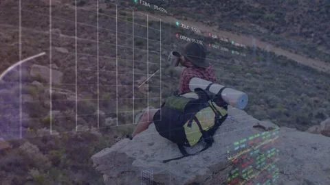 Hiker sitting cliff while raising mug, watching tech graphs growing over hiker Stock Footage 333631692