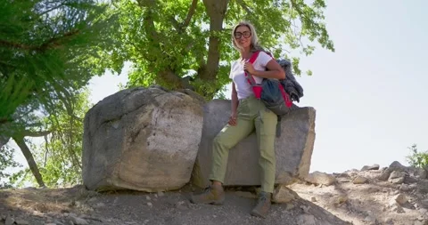 Hiker Standing Beside Boulder in Forested Area Stock Footage 323903363