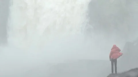 Hiker standing in front of a huge waterfall Stock Footage 79791319