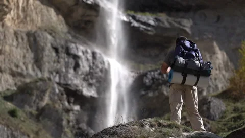Hiker Standing in Front of Waterfall Watching the Flow Video stock 318843752