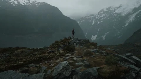 Hiker standing, looking at the cold large mountains around her Stock Footage 140611572