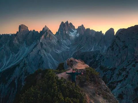 Hiker Standing on Rocky Summit With Dramatic Jagged Mountain Peak in Dolomi.. Stock Photos