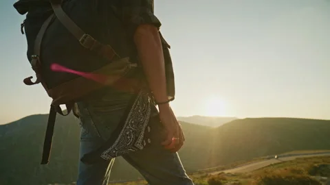 Hiker stands on mountain trail during sunset Stock Footage 345632290