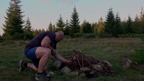 Hiker starting campfire at dawn Stock Footage 249334568