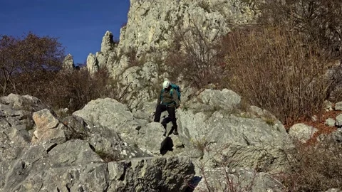 Hiker on the steep scree terrain to the summit of the mountain Stock Footage 224064337