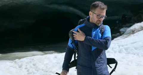 Hiker taking DJI Mavic 4 Pro drone from backpack near ice cave in winter 動画素材 336658077