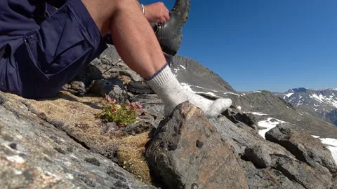 Hiker ties the lace of his boot on mountain top in Norway Stock Footage 156784114