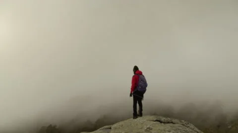 Hiker on top of the mountain covered with mist Stock Footage 149758908