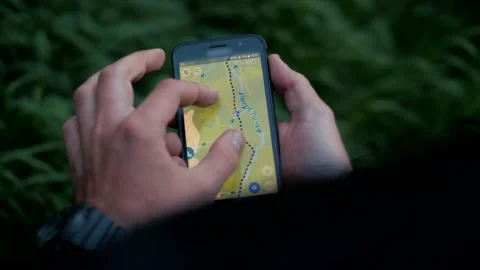 Hiker traces a route through the map app on the phone and checks the time Stock Footage 138689919