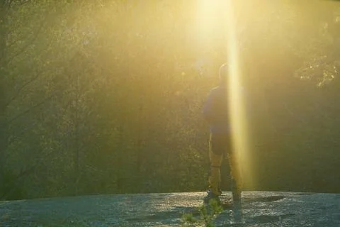 A hiker under the rays of sunset in forest. Foto stock