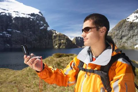 Hiker Using Compass By Mountain Lake Stock Photos